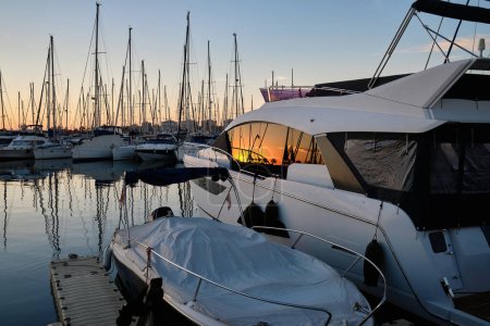 Photo for Yacht parking in the marina at sunset. Sea bay with yachts at sunset.Moored yachts. Marina, port. reflection of boat masts in sea water at sunset. Torrevieja, Alicante, Spain - Royalty Free Image