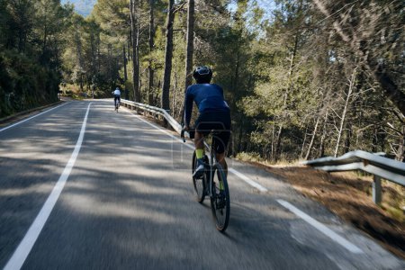 Ein junger männlicher Radfahrer, der auf einem Schotterfahrrad bergauf fährt. Sportler, die hart auf dem Fahrrad im Freien trainieren.Sport Motivation.Region Alicante in Spanien.