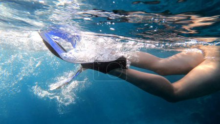 Foto de Swimming with fins. Girl is swimming, underwater shot - Imagen libre de derechos