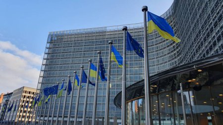 Photo for Ukrainian and EU flags flying outside the European Commission headquarters (Berlaymont) in Brussels, Belgium. 25 February 2023. - Royalty Free Image