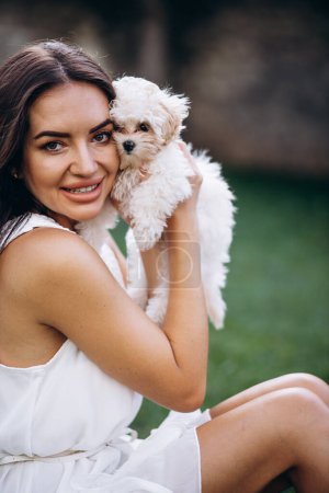 Photo for Beautiful woman holding her little maltipa dog - Royalty Free Image