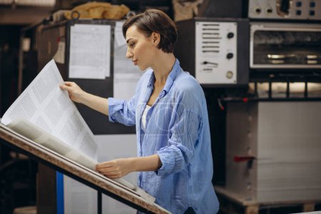 Téléchargez les photos : Femme travaillant dans l'imprimerie avec du papier et des peintures - en image libre de droit