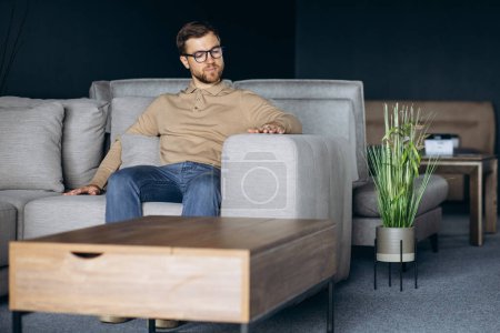 Photo for Man in furniture store choosing sofa - Royalty Free Image