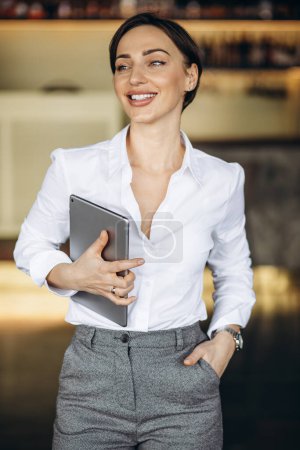 Téléchargez les photos : Femme d'affaires tenant la tablette dans un café - en image libre de droit