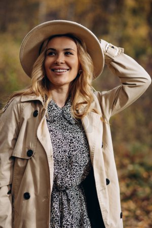 Foto de Hermosa mujer con sombrero y abrigo caminando en el parque de otoño - Imagen libre de derechos