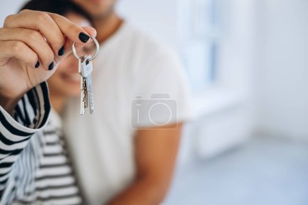 Young family holding keys from their new home