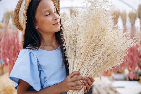 Foto de Linda niña con orejas secas decorativas de maíz - Imagen libre de derechos