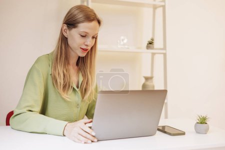 Photo for Young woman working on laptop at the desk - Royalty Free Image