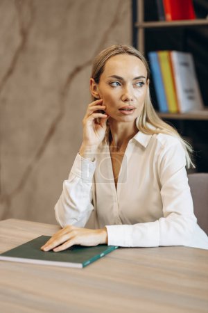 Photo for Woman sitting at the desk st the office - Royalty Free Image