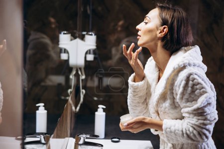 Photo for Woman applying moisturizing face cream - Royalty Free Image