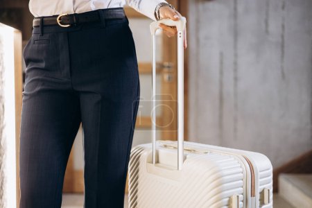 Téléchargez les photos : Femme d'affaires avec bagages de voyage à l'hôtel - en image libre de droit