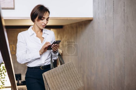 Téléchargez les photos : Femme d'affaires monter les escaliers de la chambre d'hôtel et parler au téléphone - en image libre de droit