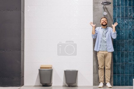Téléchargez les photos : Homme au marché du bâtiment choisir douche pour sa salle de bain - en image libre de droit
