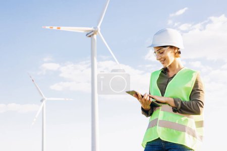 Téléchargez les photos : Femme travaillant sur tablette, contrôlant le fonctionnement des éoliennes - en image libre de droit