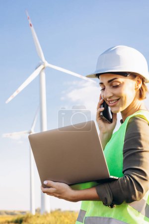 Photo for Portrait of woman talking on the phone by the windmill tribunes - Royalty Free Image