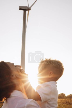 Téléchargez les photos : Mère avec son fils étreignant par les éoliennes - en image libre de droit