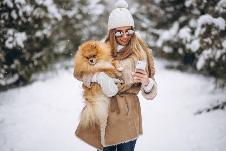 Téléchargez les photos : Femme avec chien et téléphone en hiver - en image libre de droit