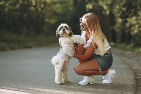 Photo for Pretty woman with her dog out in the park - Royalty Free Image