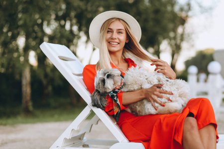 Téléchargez les photos : Jolie femme avec son chien mignon en vacances - en image libre de droit