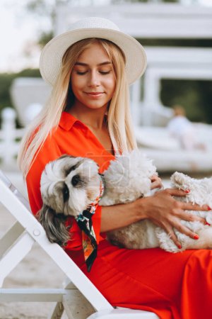 Téléchargez les photos : Jolie femme avec son chien mignon en vacances - en image libre de droit