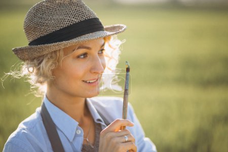 Photo for Woman artist painting with oil paints in a field - Royalty Free Image