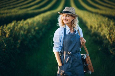 Photo for Woman artist painting with oil paints in a field - Royalty Free Image