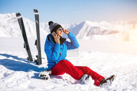Foto de Mujer esquiando en las montañas y hablando por teléfono - Imagen libre de derechos