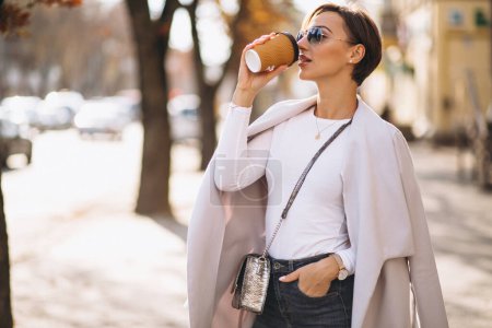 Photo for Woman wearing coat and drinking coffee - Royalty Free Image