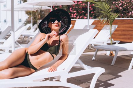 Téléchargez les photos : Belle femme en bikini au bord de la piscine - en image libre de droit