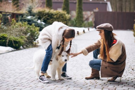 Téléchargez les photos : Mère et fille avec chien dehors - en image libre de droit