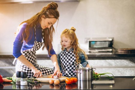 Photo for Mother and daughter cooking at home - Royalty Free Image