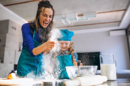 Téléchargez les photos : Mère et fille cuisinent à la maison - en image libre de droit