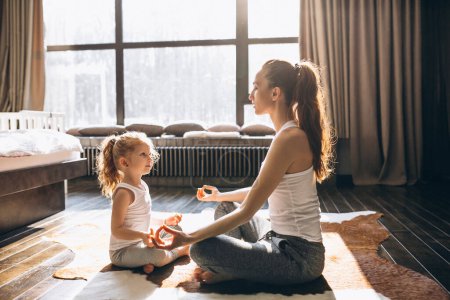 Photo for Mother and daughter yoga at home - Royalty Free Image