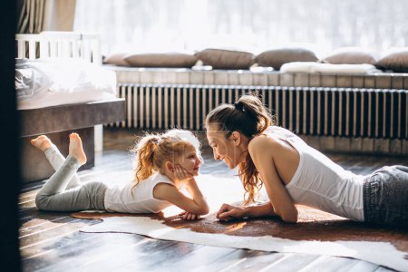 Téléchargez les photos : Mother and daughter yoga at home - en image libre de droit