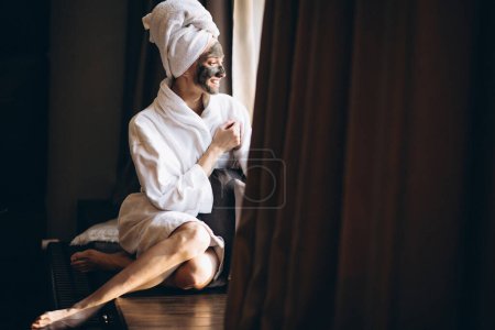 Photo for Woman with black mask on face in bathrobe - Royalty Free Image