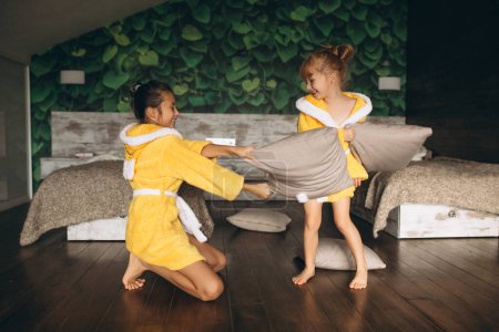 Téléchargez les photos : Sœurs se battant avec des oreillers - en image libre de droit