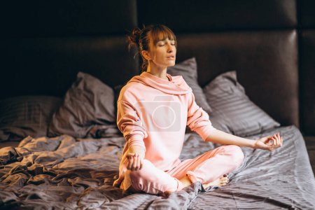 Téléchargez les photos : Femme faisant du yoga au lit - en image libre de droit