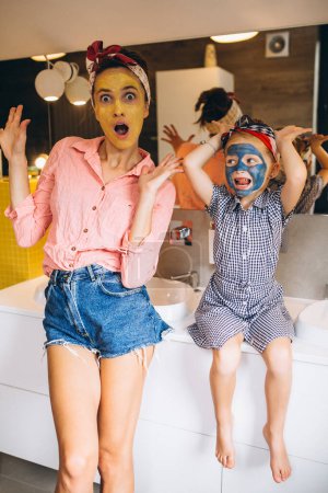 Téléchargez les photos : Mère et fille faisant des masques à la maison - en image libre de droit