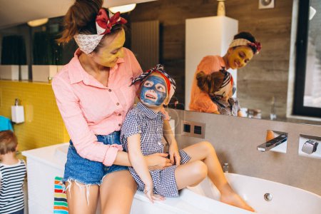 Téléchargez les photos : Mère et fille faisant des masques à la maison - en image libre de droit