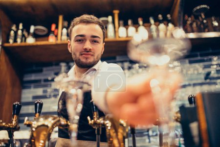 Photo for Handsome bartender making drinking and cocktails at a counter - Royalty Free Image