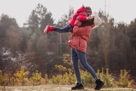 Téléchargez les photos : Mère avec petite fille dans une forêt d'hiver - en image libre de droit