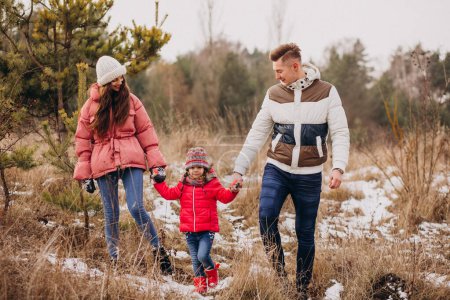 Photo for Young family together walking in forest at winter time - Royalty Free Image