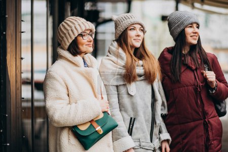 Foto de Tres amigas estudiantes en traje de invierno fuera de la calle - Imagen libre de derechos