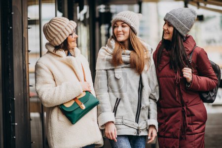 Foto de Tres amigas estudiantes en traje de invierno fuera de la calle - Imagen libre de derechos
