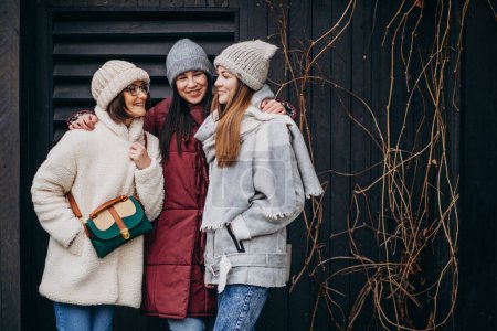 Foto de Chicas amigas reunidas en invierno fuera de la calle - Imagen libre de derechos