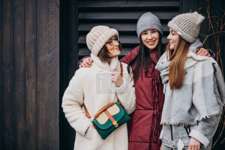Foto de Chicas amigas reunidas en invierno fuera de la calle - Imagen libre de derechos