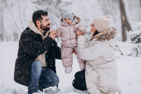 Photo for Young family with little daughter in a winter forest full of snow - Royalty Free Image
