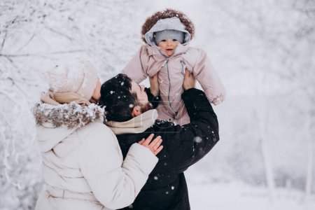 Téléchargez les photos : Jeune famille avec petite fille dans une forêt d'hiver pleine de neige - en image libre de droit