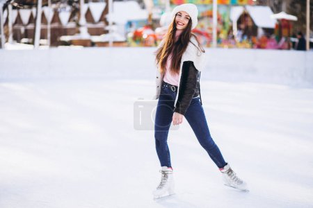 Foto de Mujer joven patinando sobre hielo en una pista en un centro de la ciudad - Imagen libre de derechos