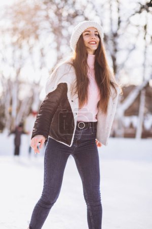 Téléchargez les photos : Jeune femme patinant sur une patinoire dans un centre-ville - en image libre de droit